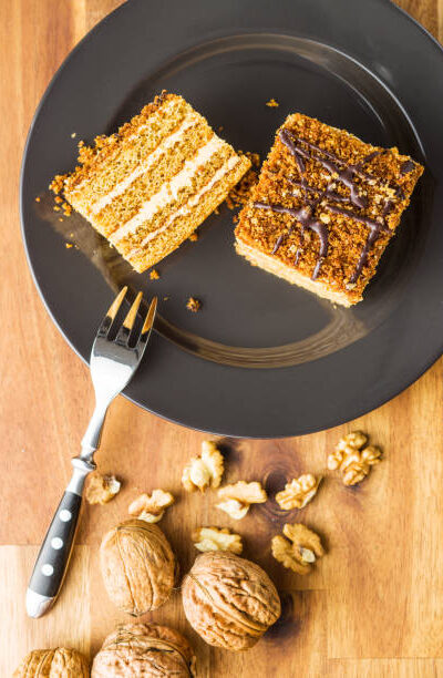 Cake with walnuts and honey on plate. top view.